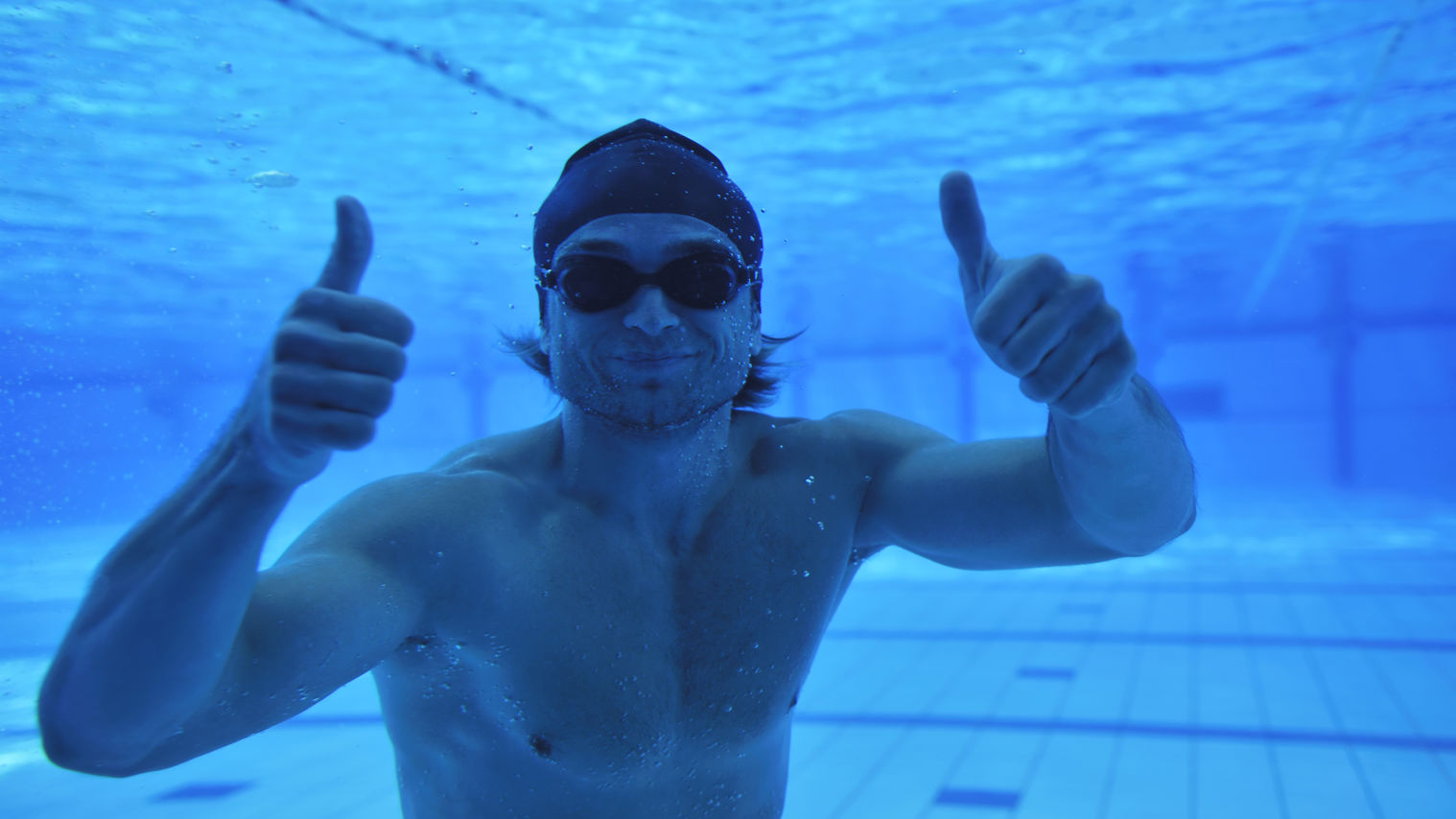Billede af mand under vand der vender tommelfingrene op