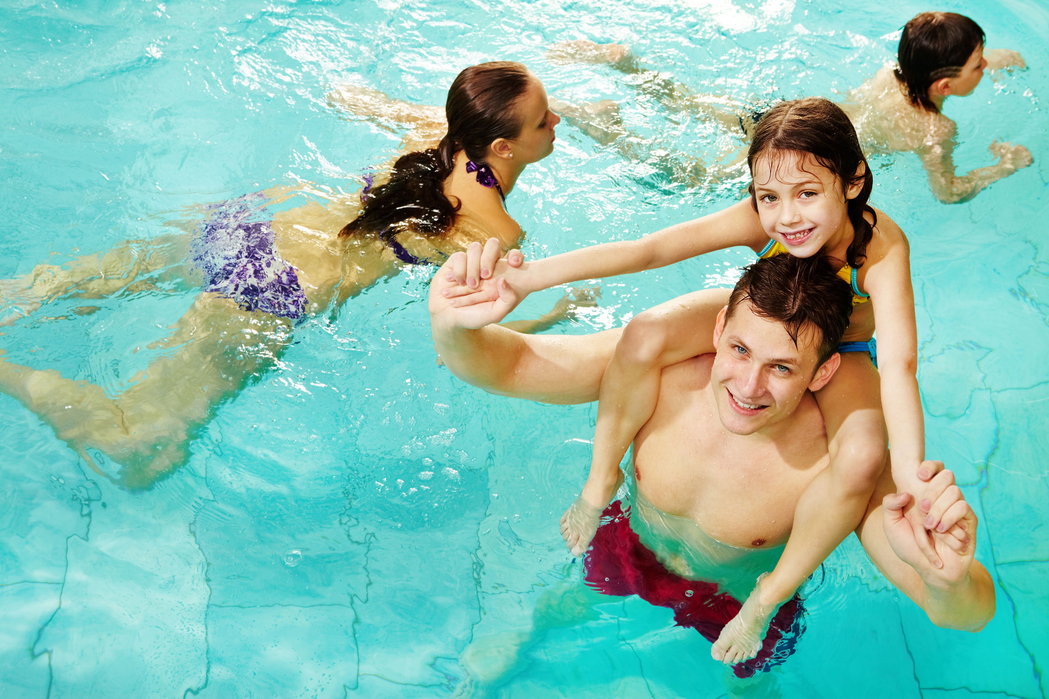 Ung mand med pige på skulderen i vandet